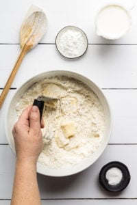 Mixing butter into southern biscuit dough in a bowl