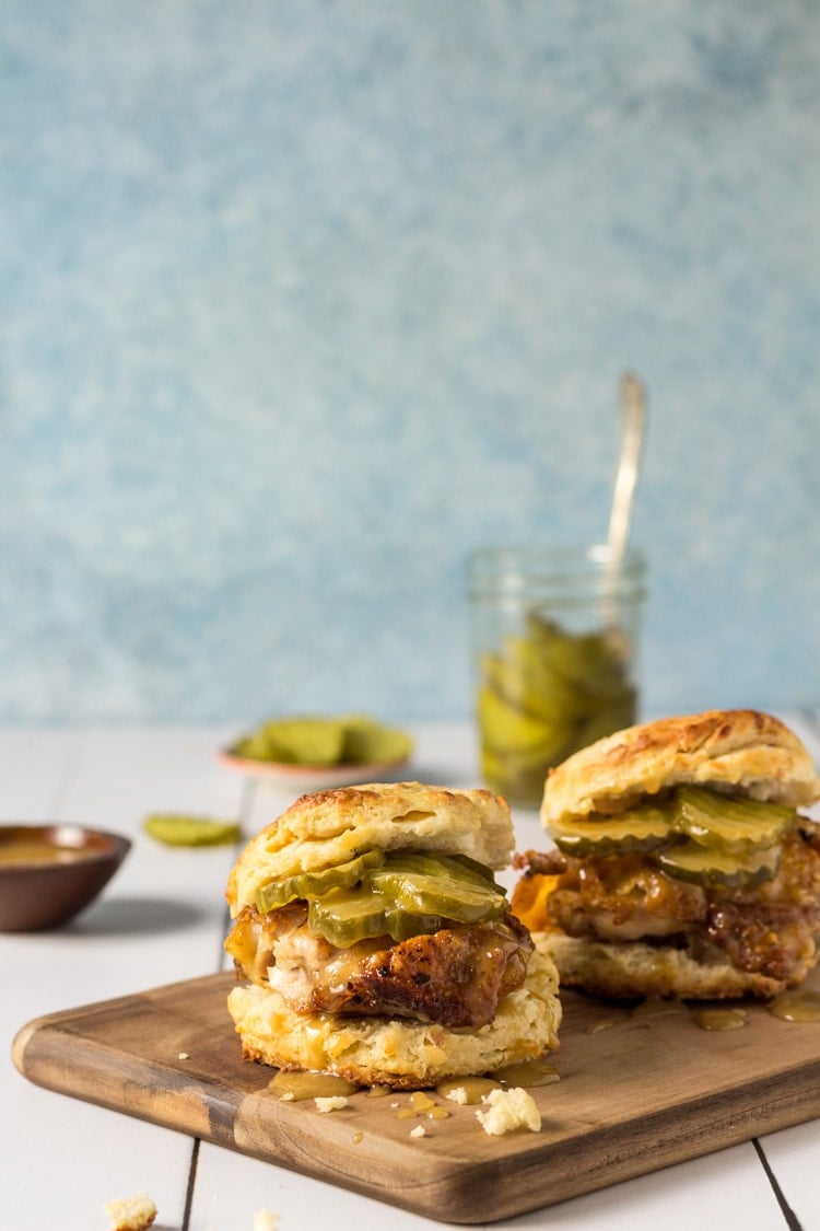 Chicken biscuit recipe with honey mustard and pickles on a cutting board