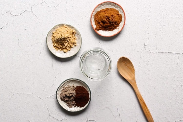 Chai Spice recipe with cinnamon, cardamom, ginger, cloves on little plates