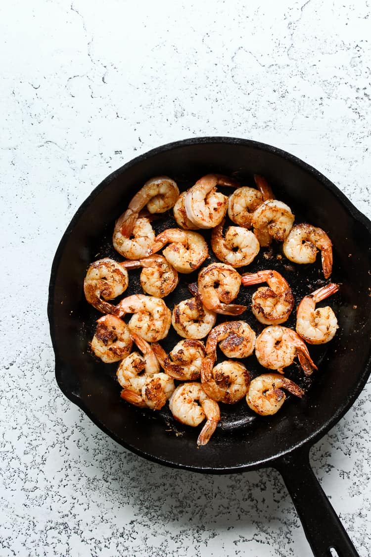 Sauteed shrimp in a cast iron skillet for fajita bowls