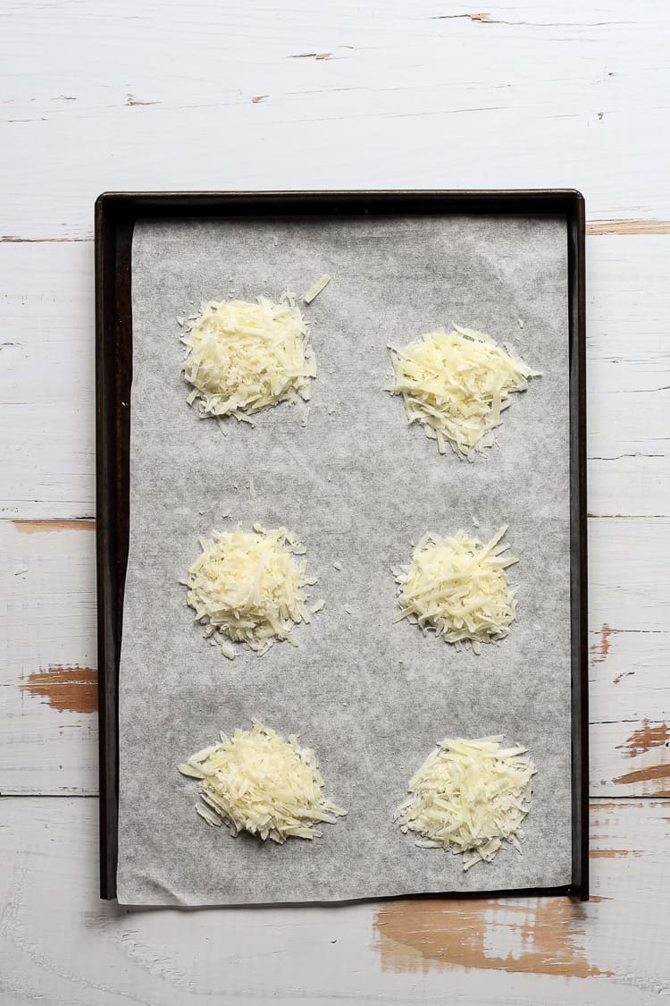 Shredded pecorino Romano crisps on a baking sheet