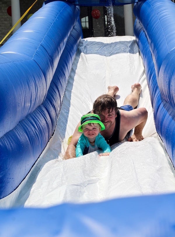 Dad and son sliding down water slide