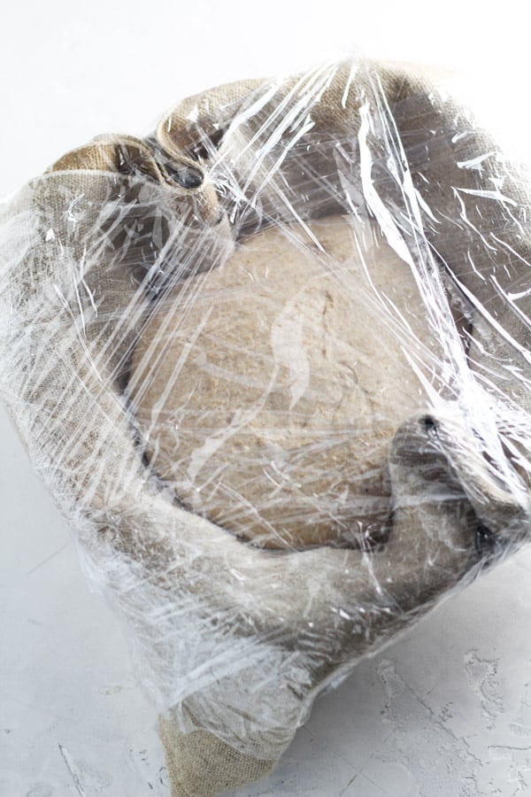 Sourdough honey splet bread covered in plastic wrap