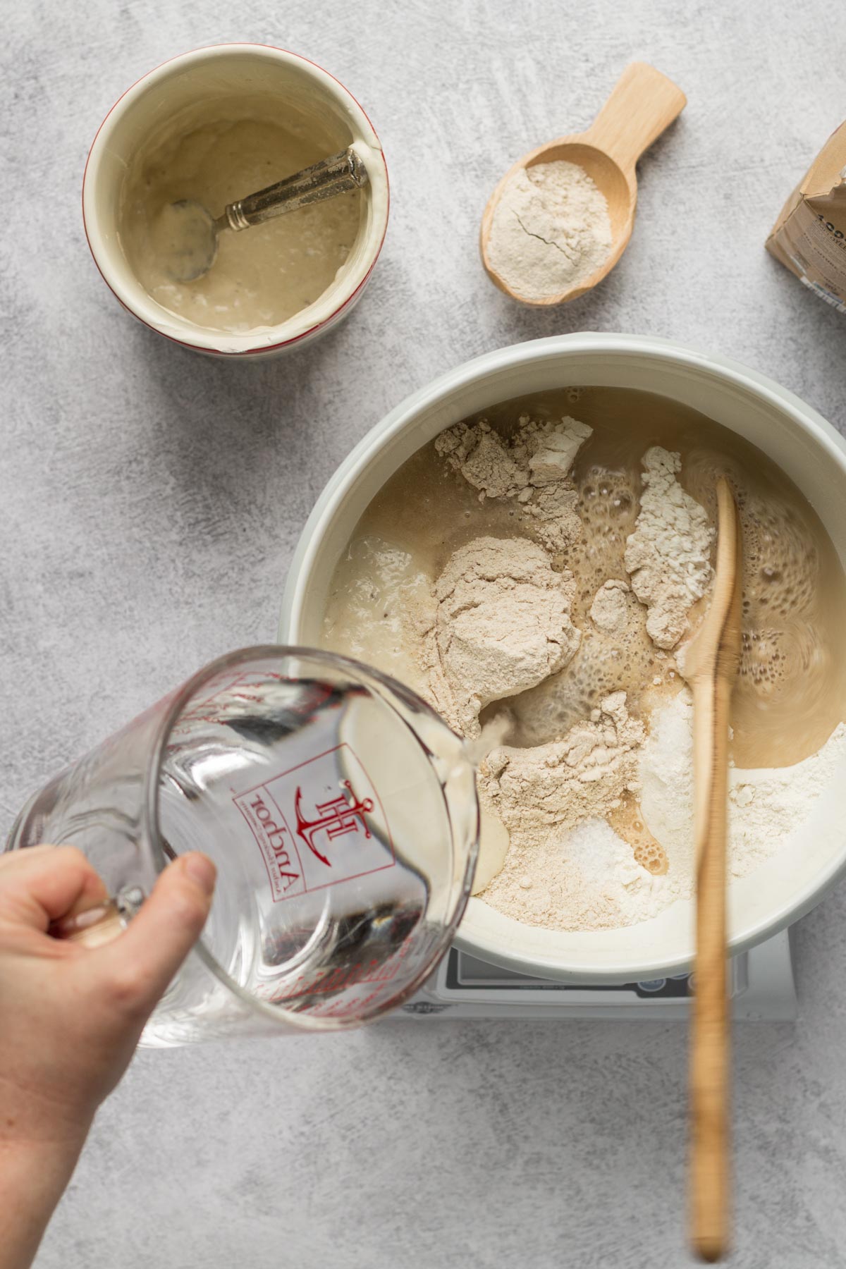 Pouring water into a bowl for bread dough