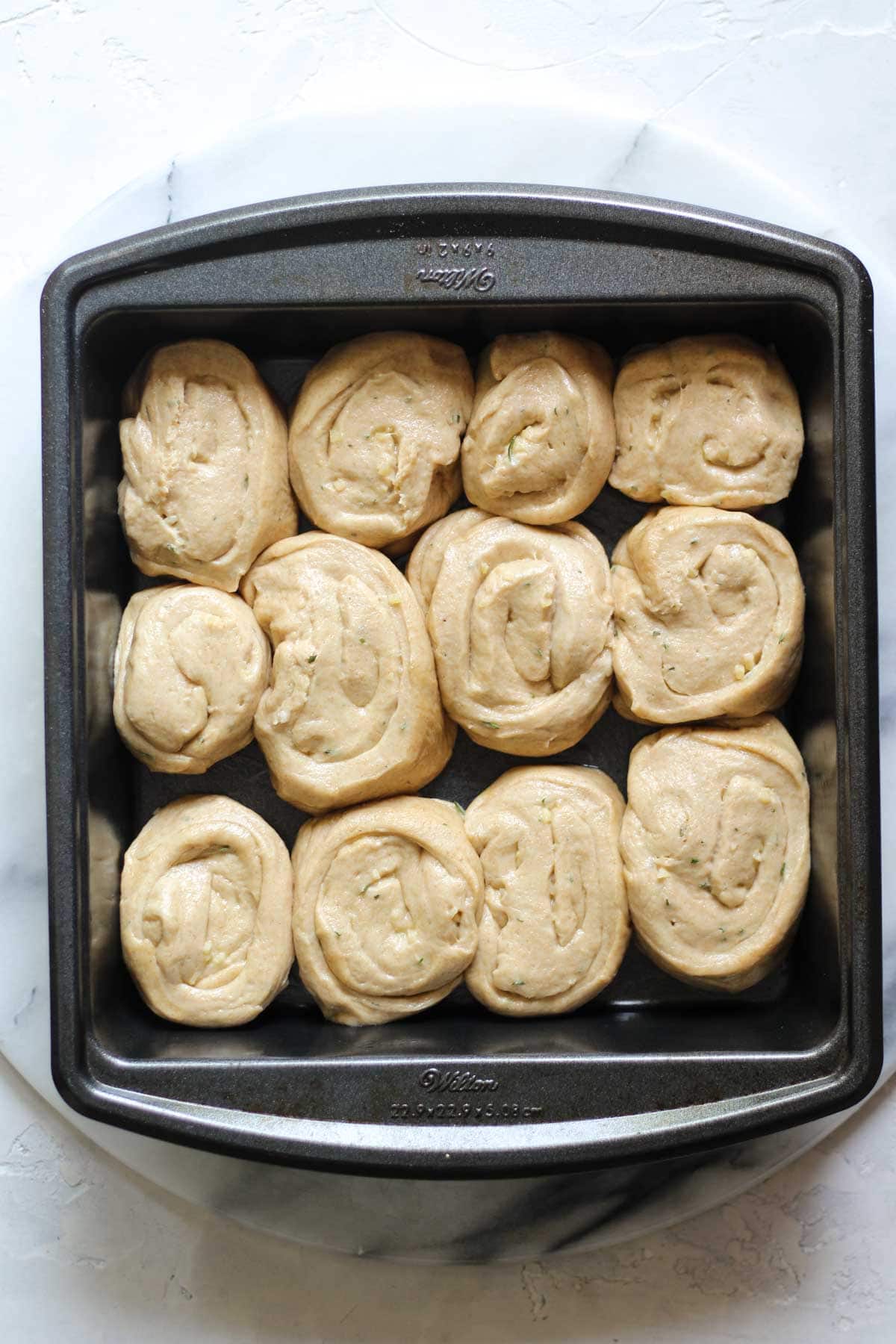 Sourdough garlic rosemary rolls in a pan