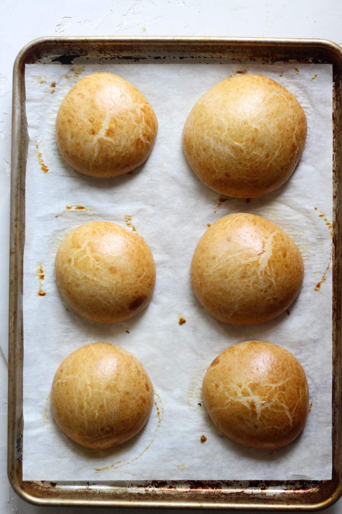 Baked sourdough hamburger buns on a pan