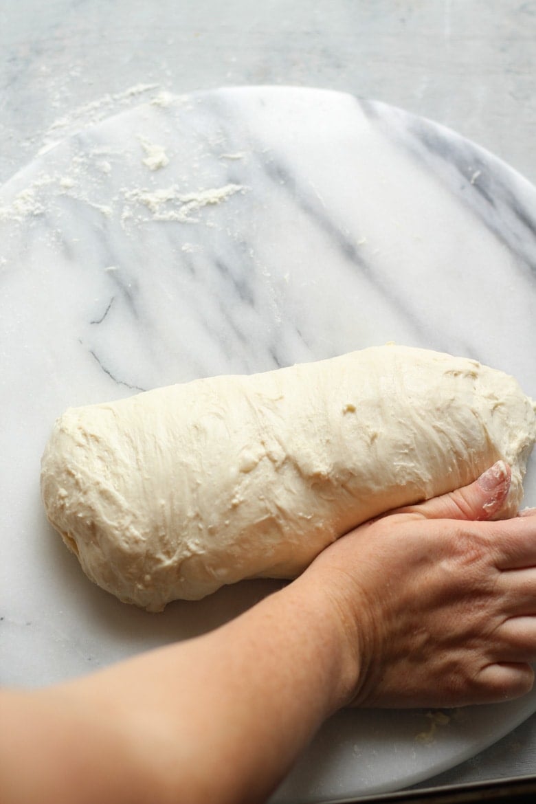 Shaping sourdough bread dough in a log or batard for a loaf tin