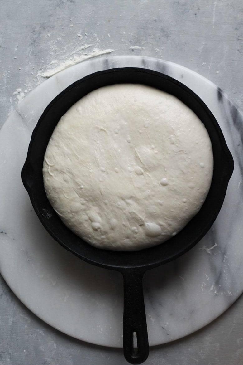 Sourdough bread recipe proofing in a cast iron skillet and ready to bake