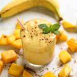 Mango smoothie in a cup with fresh mango