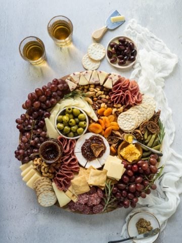 A charcuterie cheese board on a wooden board with a linen napkin