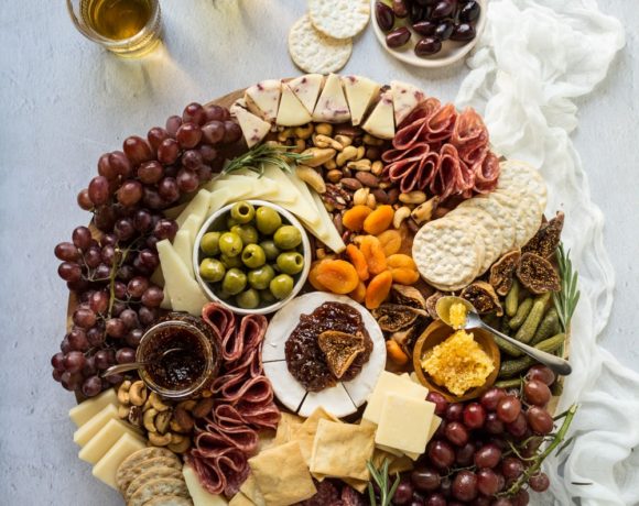 A charcuterie cheese board on a wooden board with a linen napkin