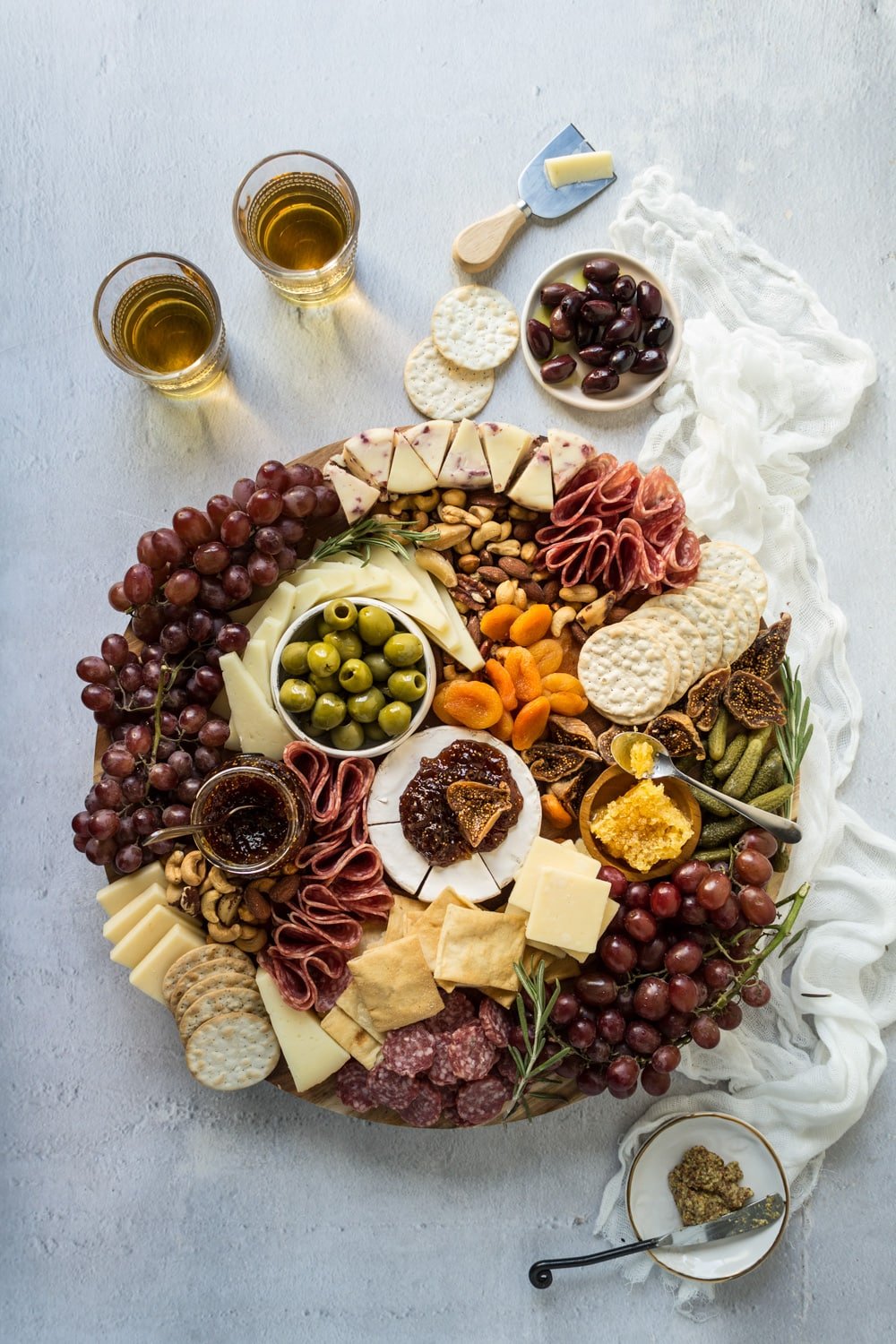 A charcuterie cheese board on a wooden board with a linen napkin