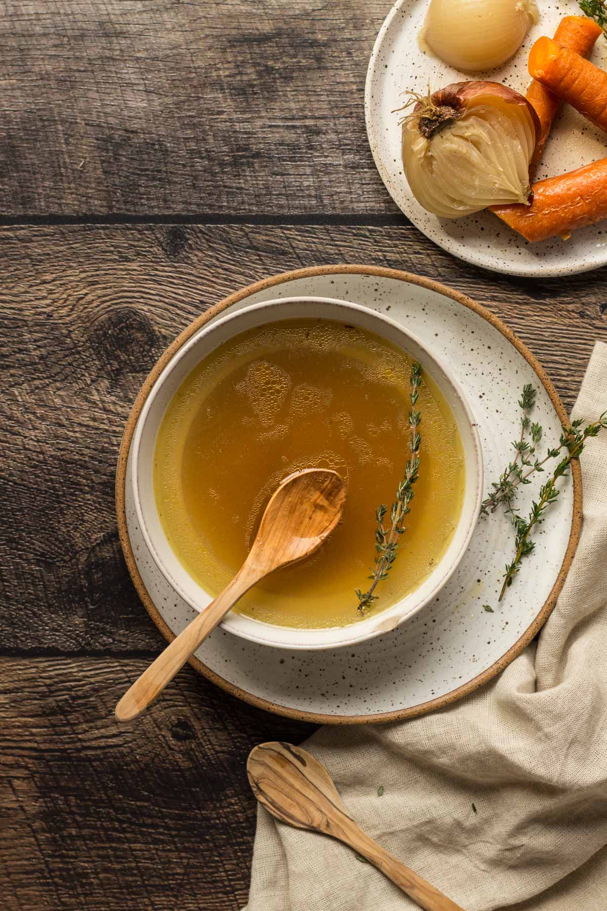 Chicken stock in a bowl with fresh thyme
