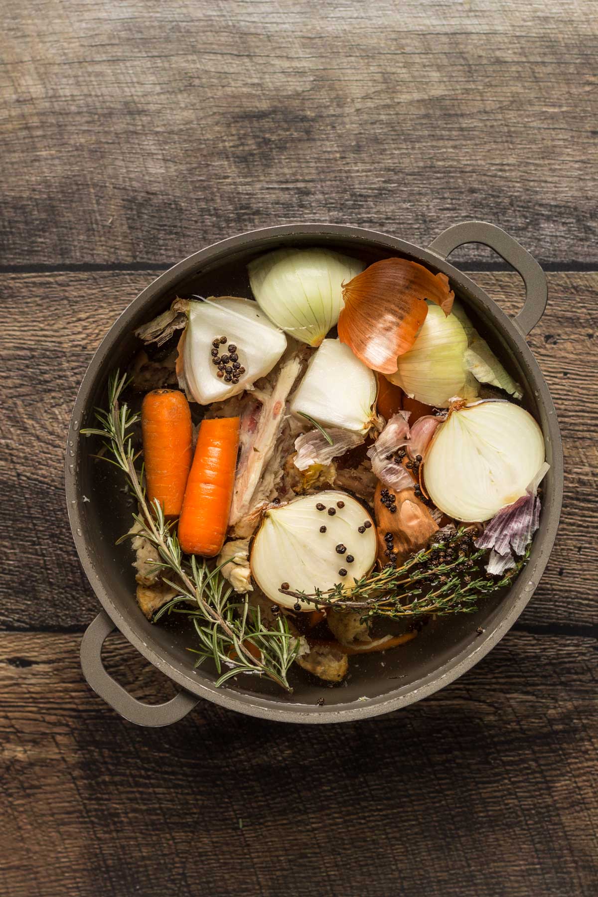 Onions, carrots, and herbs in a stock pot