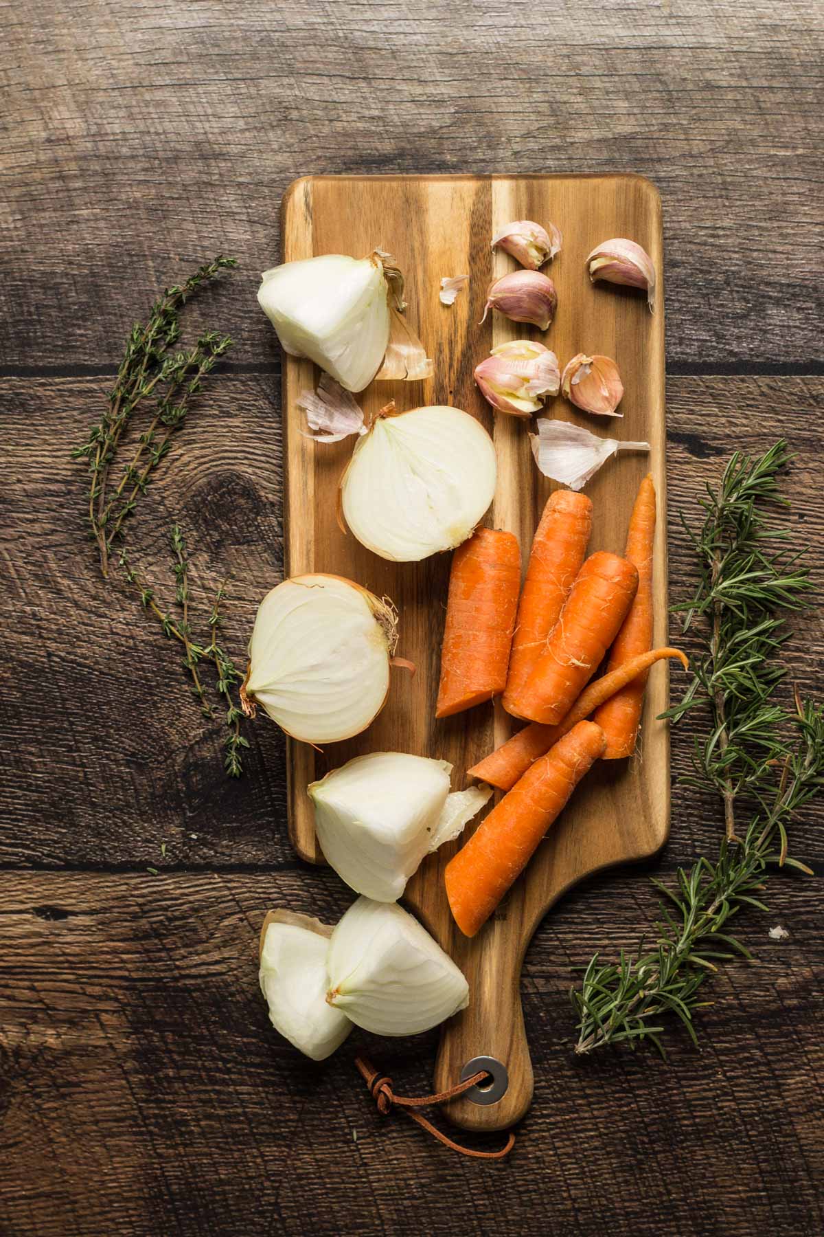 Onions, garlic, and carrots on a cutting board