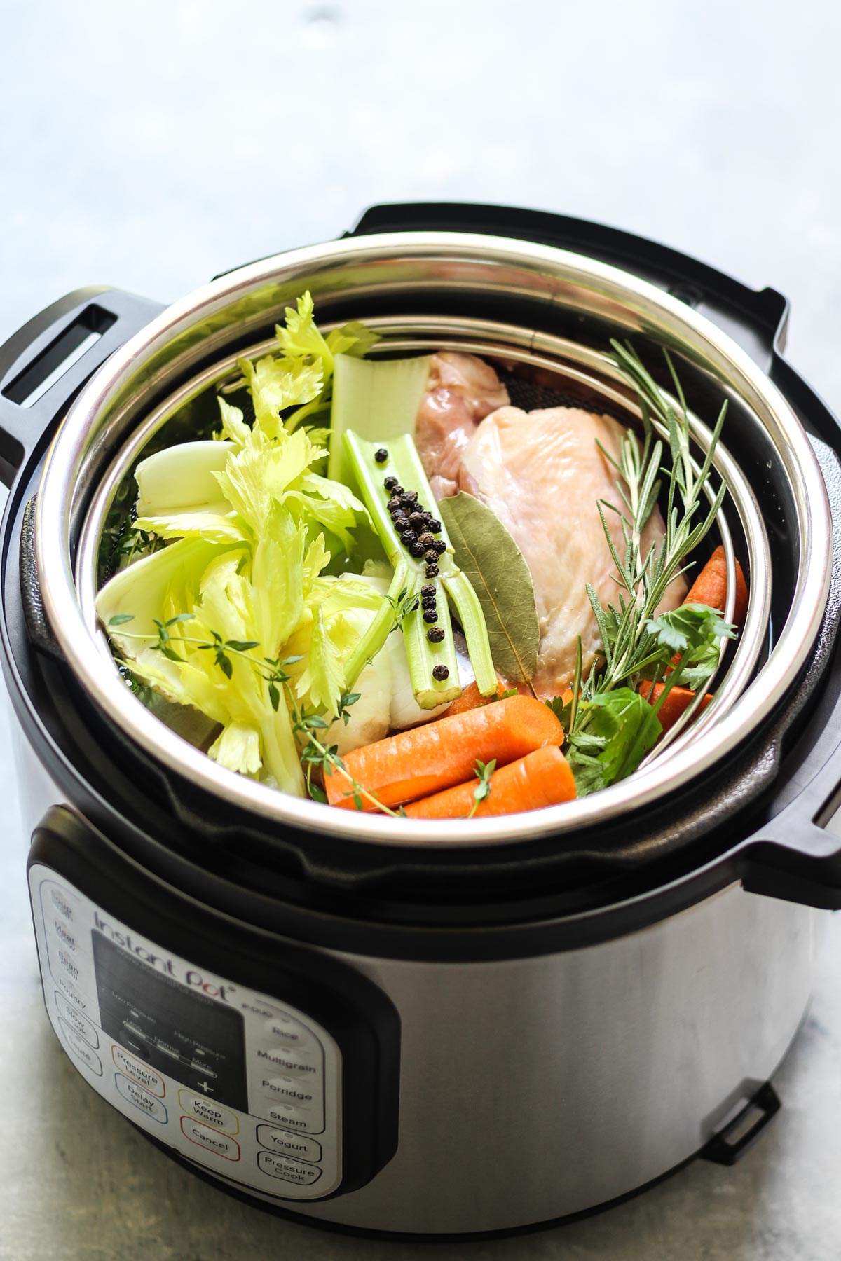 carrots, onions, and herbs in an instant pot