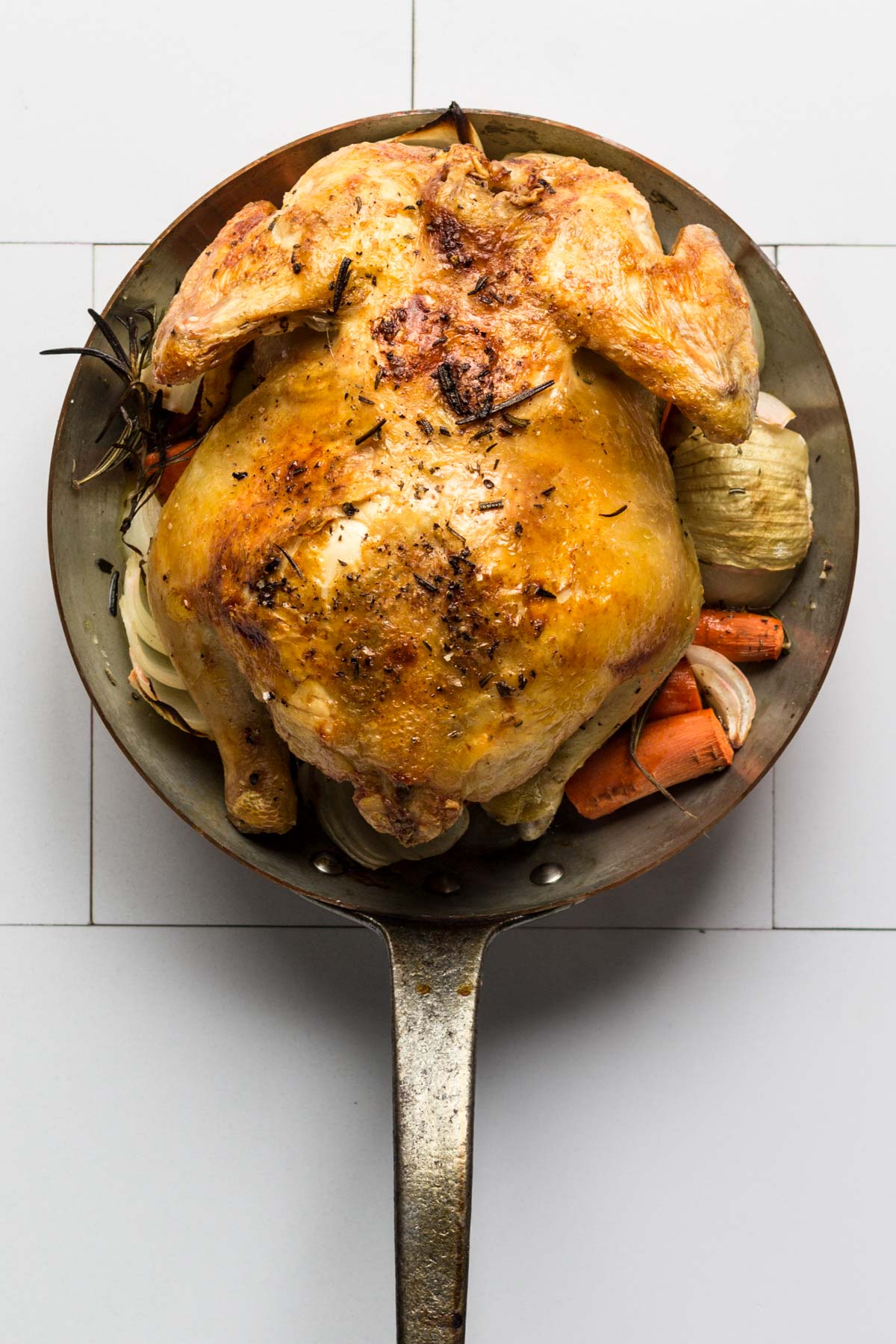 Roasted chicken in a saute pan breast-side-down