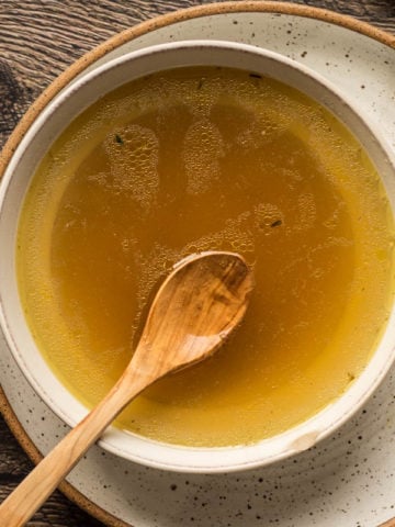 chicken stock in a bowl with fresh thyme