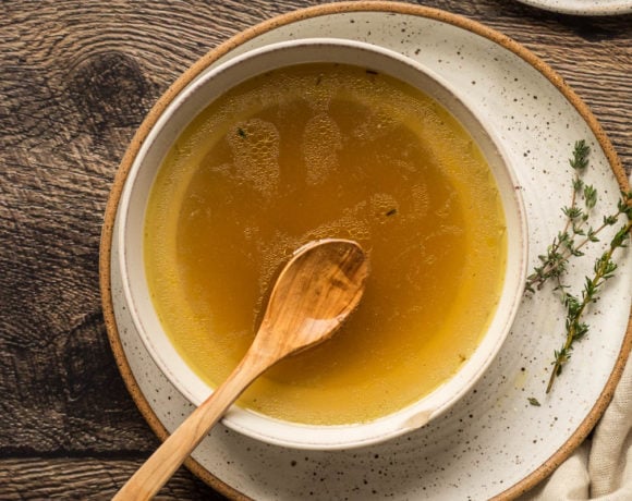 chicken stock in a bowl with fresh thyme