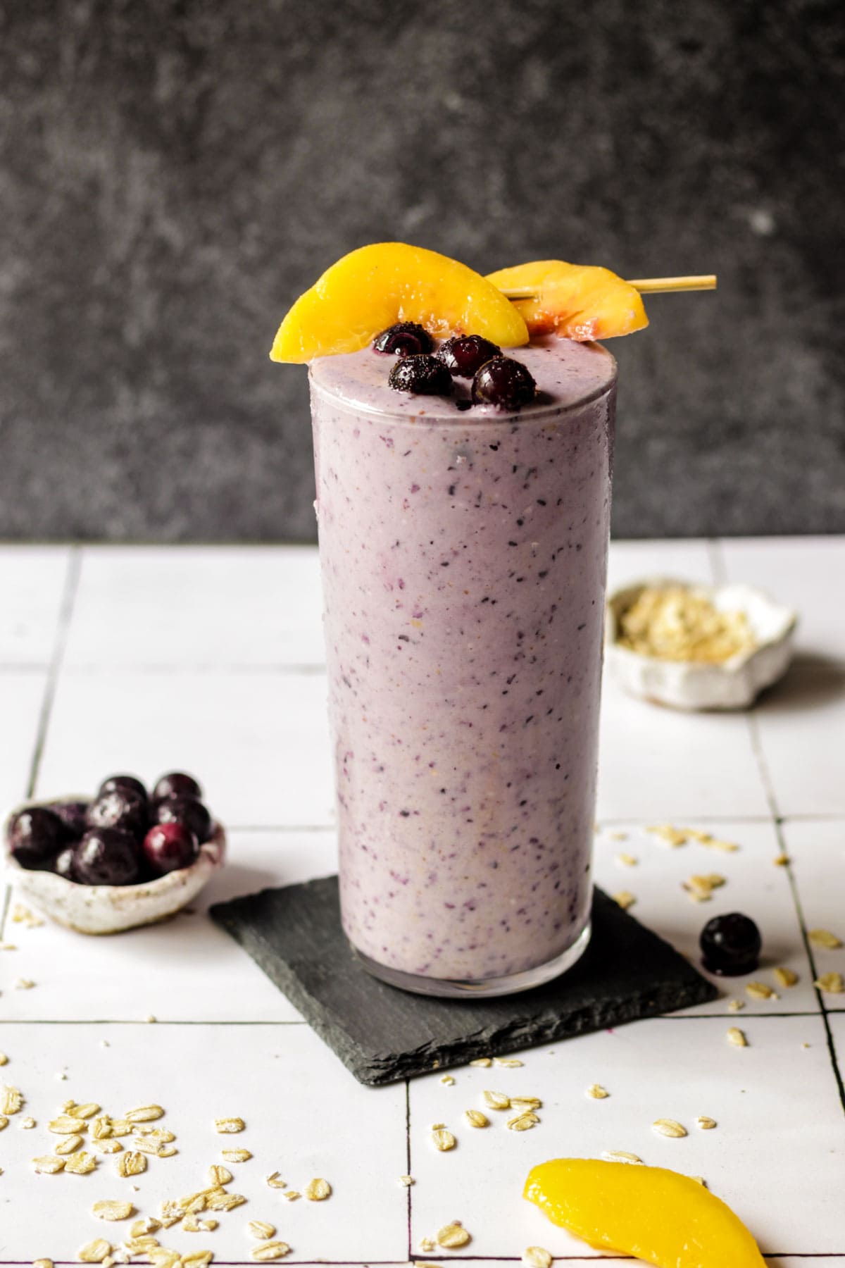 Blueberry smoothie in a glass with peaches on top