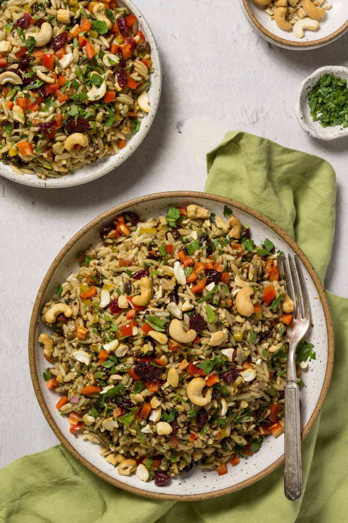 Orzo wild rice salad in a pottery bowl with a green napkin