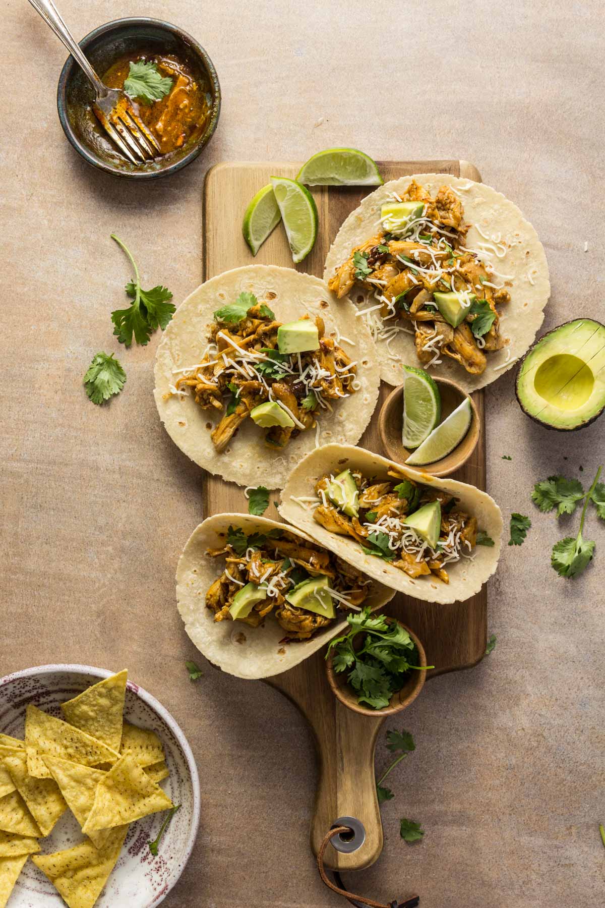 Chipotle chicken orange tacos with avocado on a wooden board