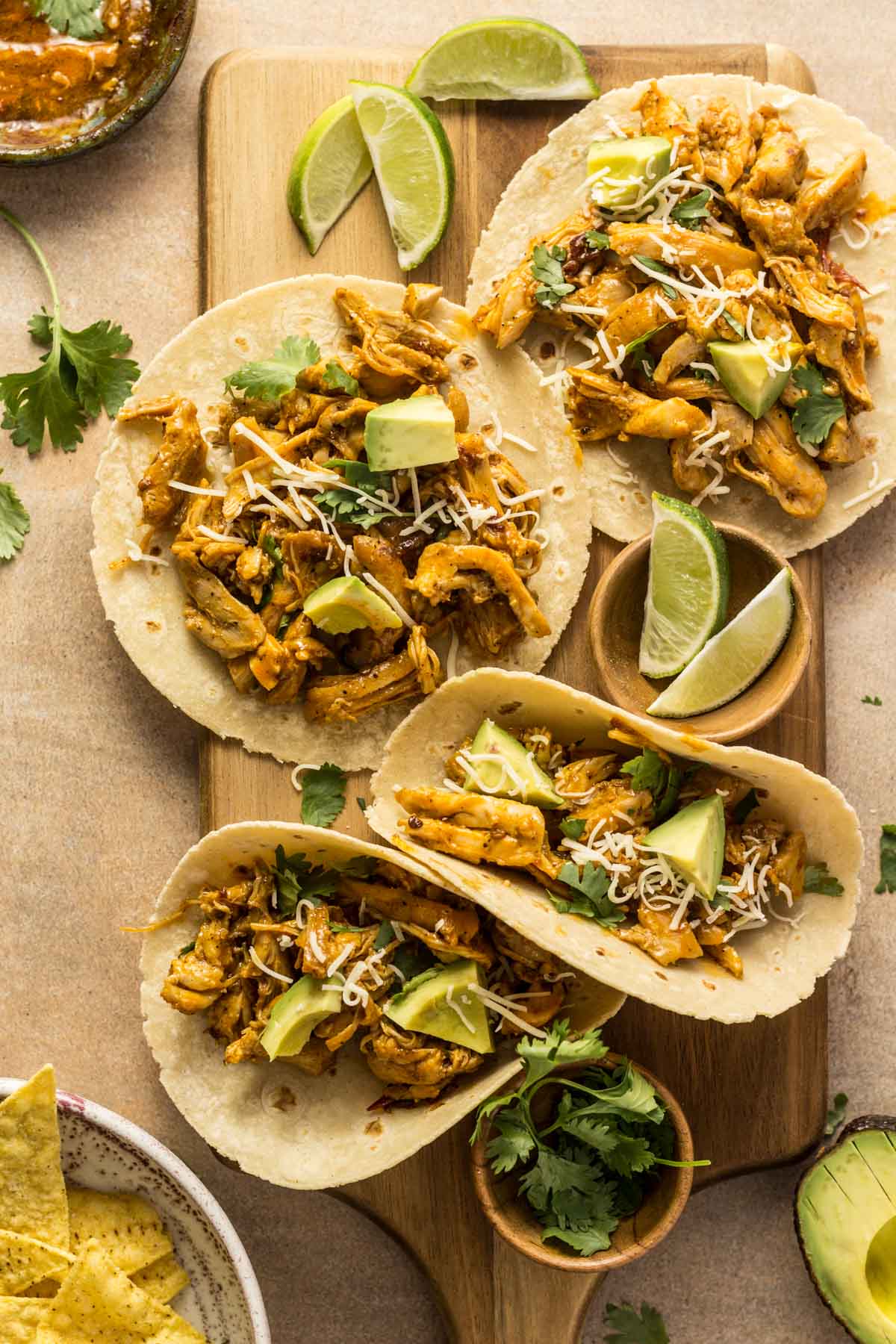 Chipotle chicken tacos with limes on a cutting board