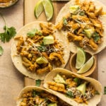 Chipotle orange tacos on a cutting board with limes