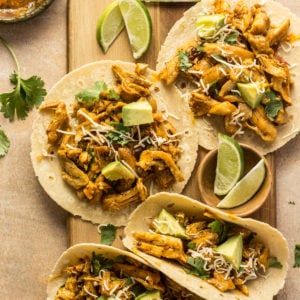 Chipotle orange tacos on a cutting board with limes