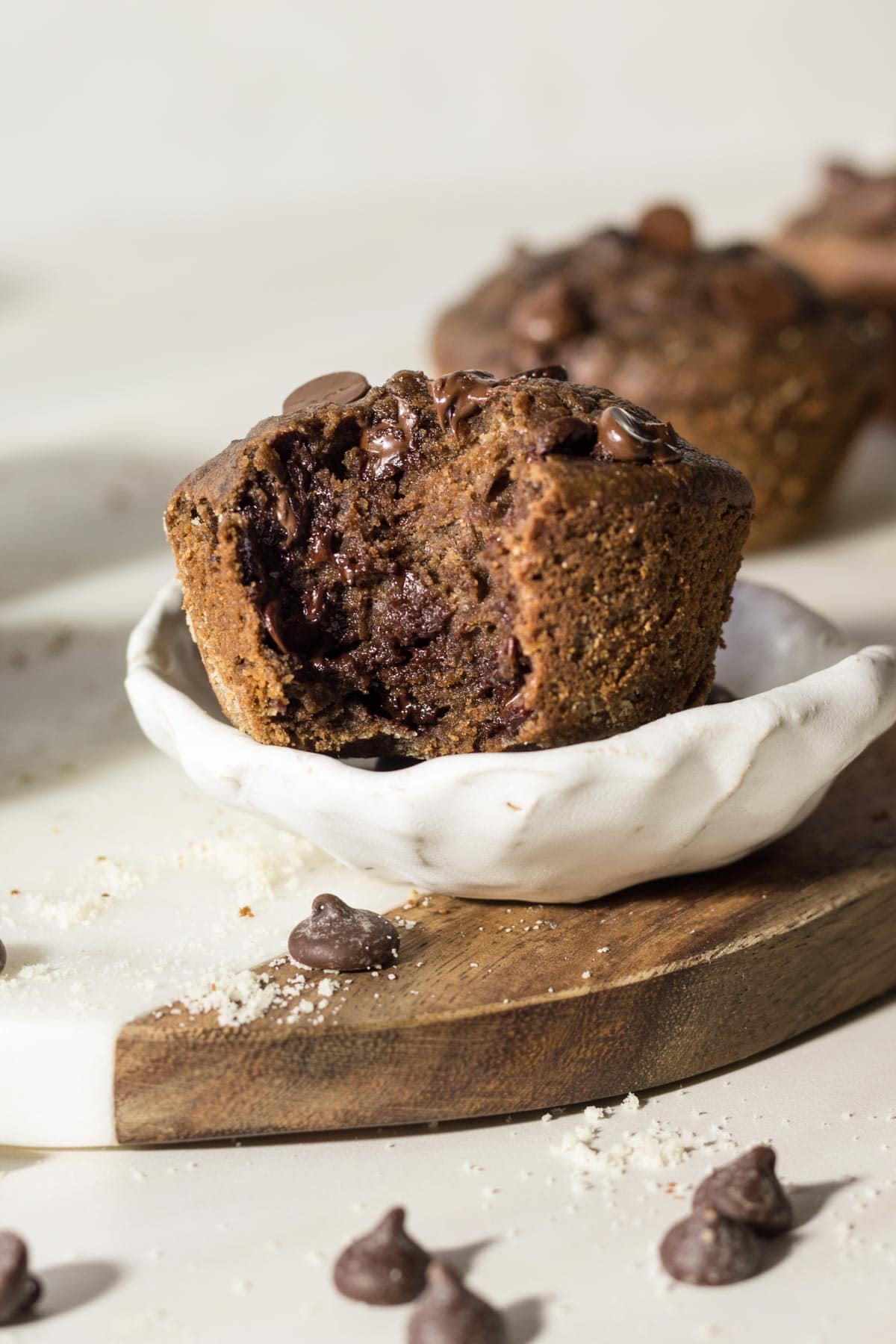 Chocolate chip muffins in a pottery bowl on a marble board