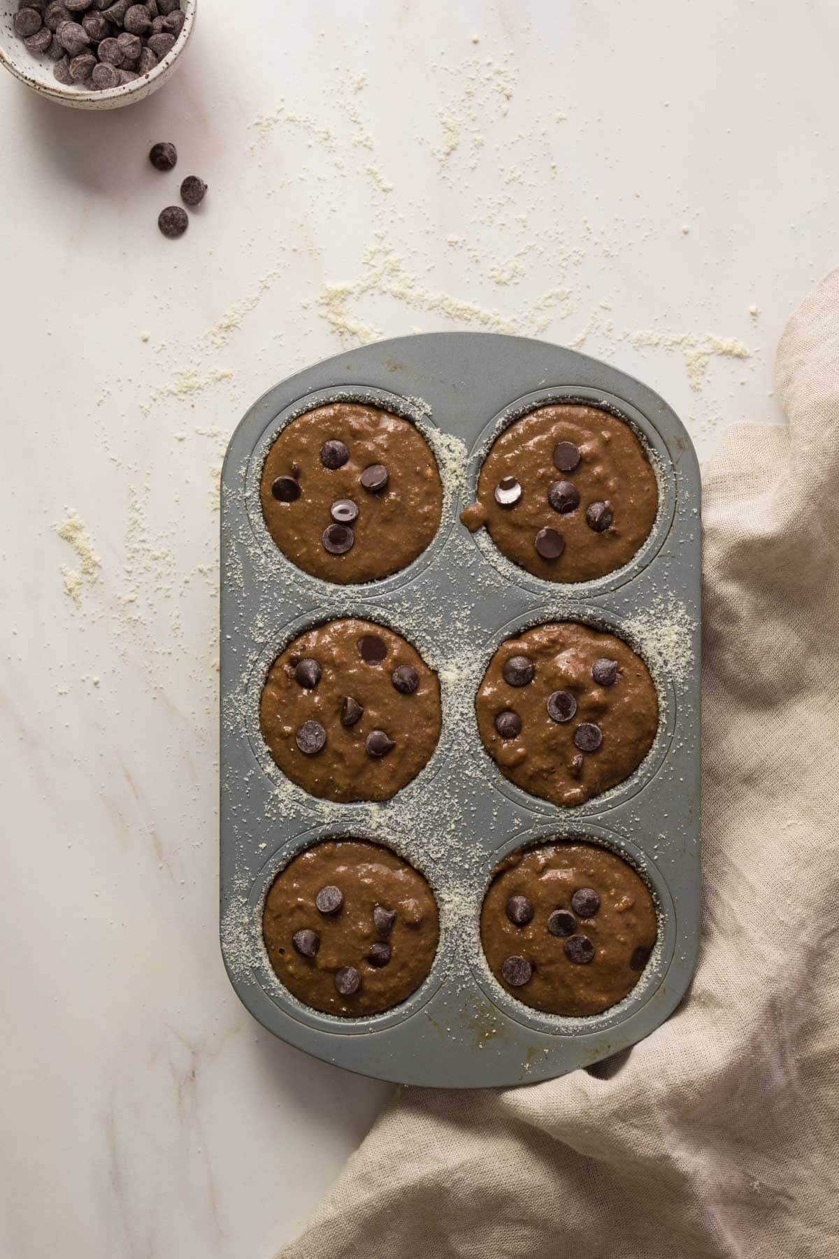 Chocolate chip muffin batter in muffin tins
