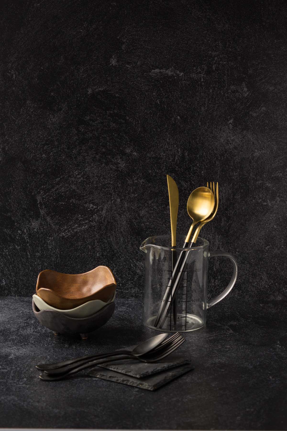 Gold and black spoons in a glass