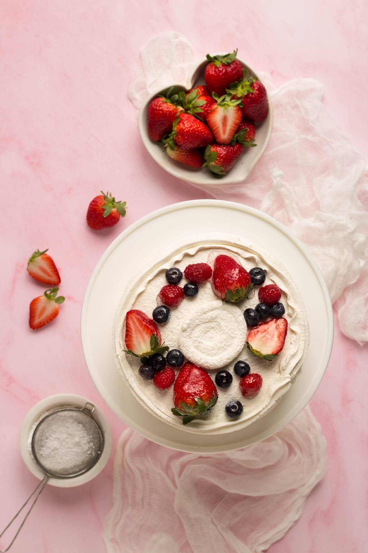 Cake with berries and a bowl of strawberries