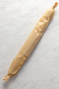 Snickerdoodle cookie dough wrapped in a parchment paper log