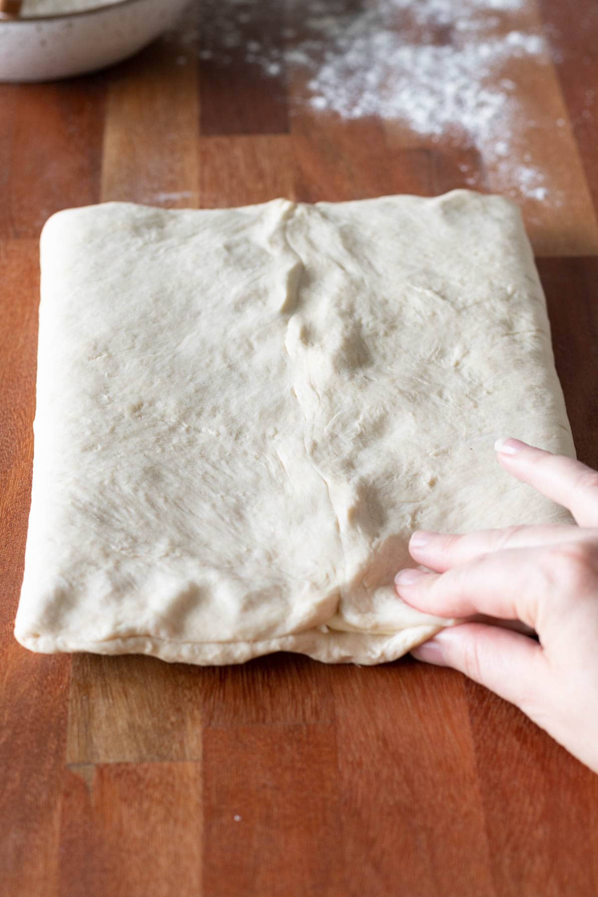 Fingers sealing croissant dough