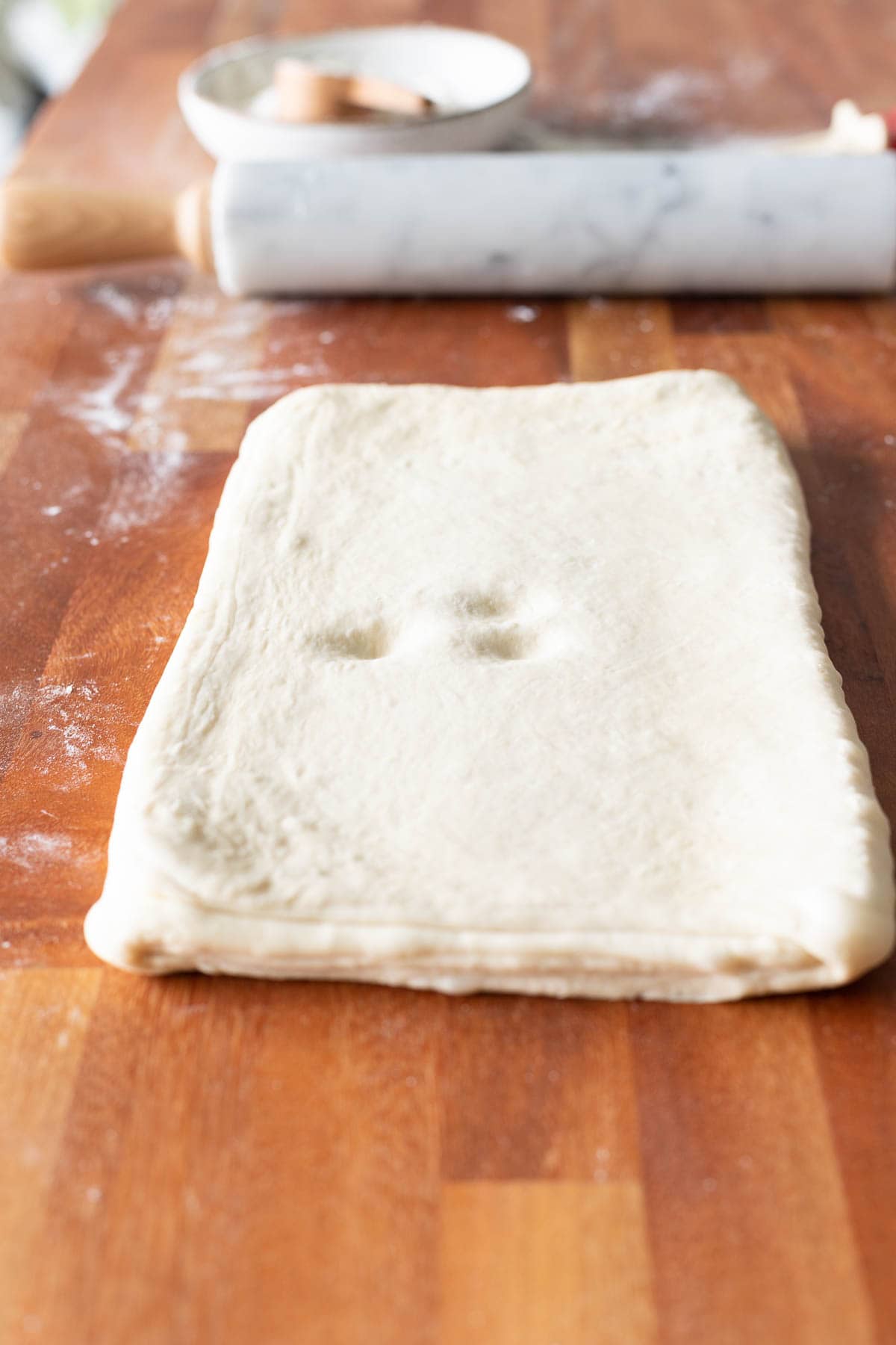 Croissant dough with three finger indentions on the surface