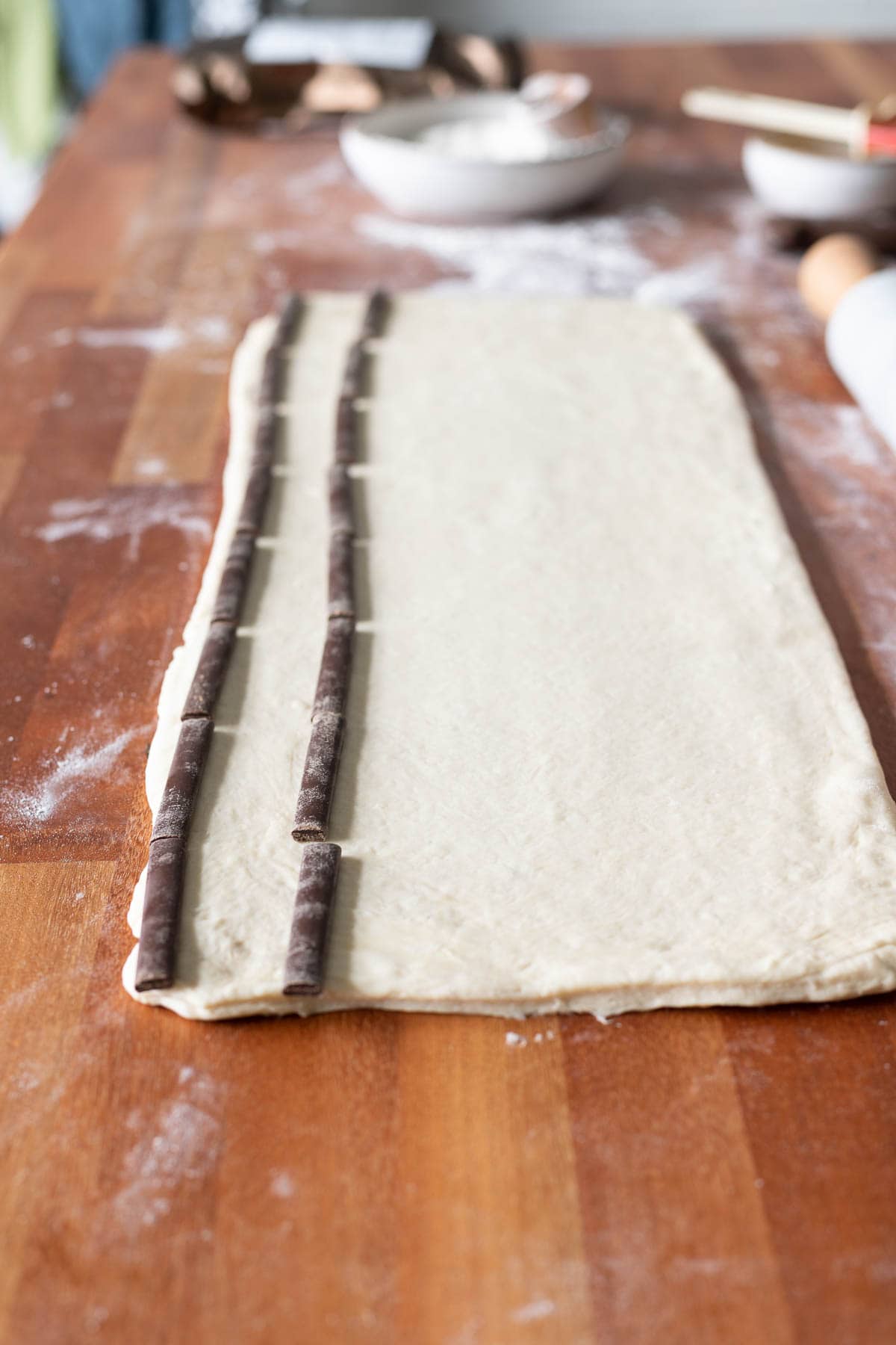 Chocolate croissant dough with chocolate batons placed on top