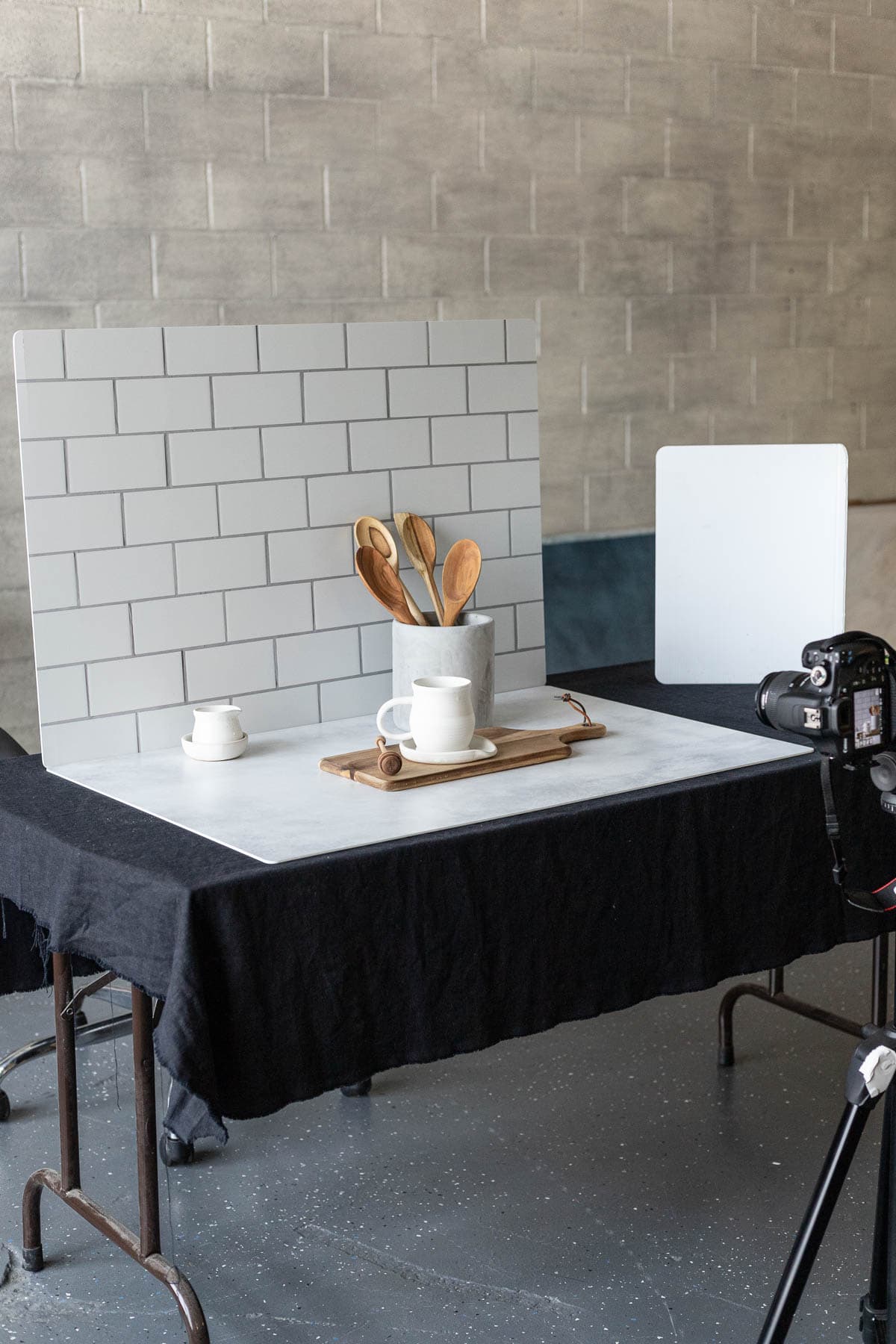 A camera on a tripod in front taking a photo with backdrops