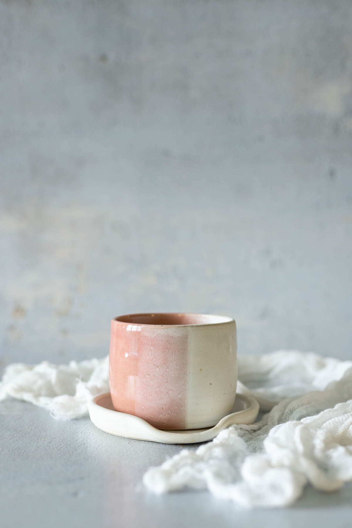 Pink pottery cup with linen cloth