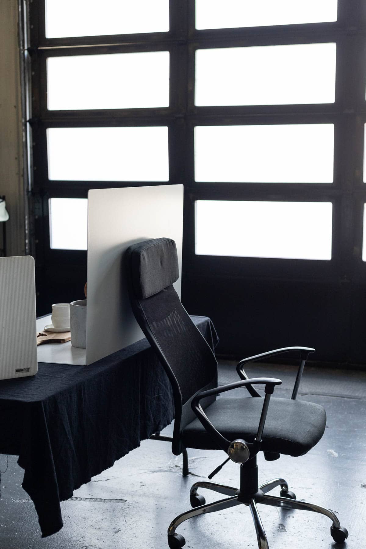 An office chair holding up a photography backdrop