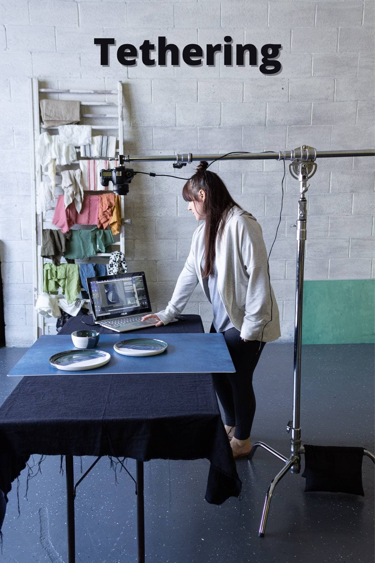 A person standing by a computer with a c-stand