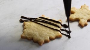 drizzling chocolate over shortbread cookie