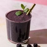 Blueberry Kale smoothie with mint and blueberries on a colorful background