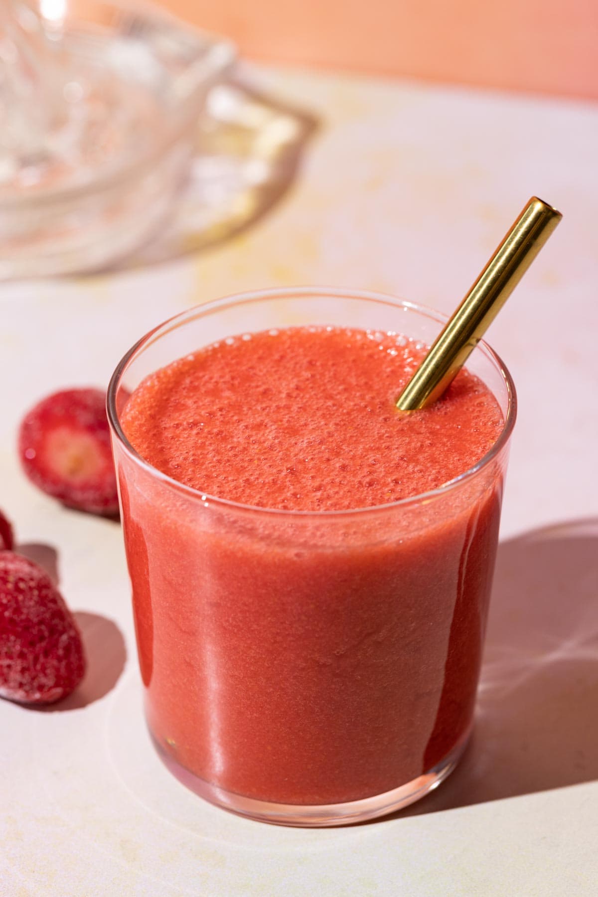 Strawberry lemonade in a glass with a metal straw