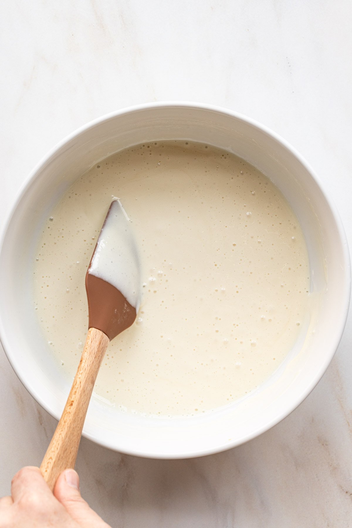 Sweetened condensed milk in a bowl with a spatula