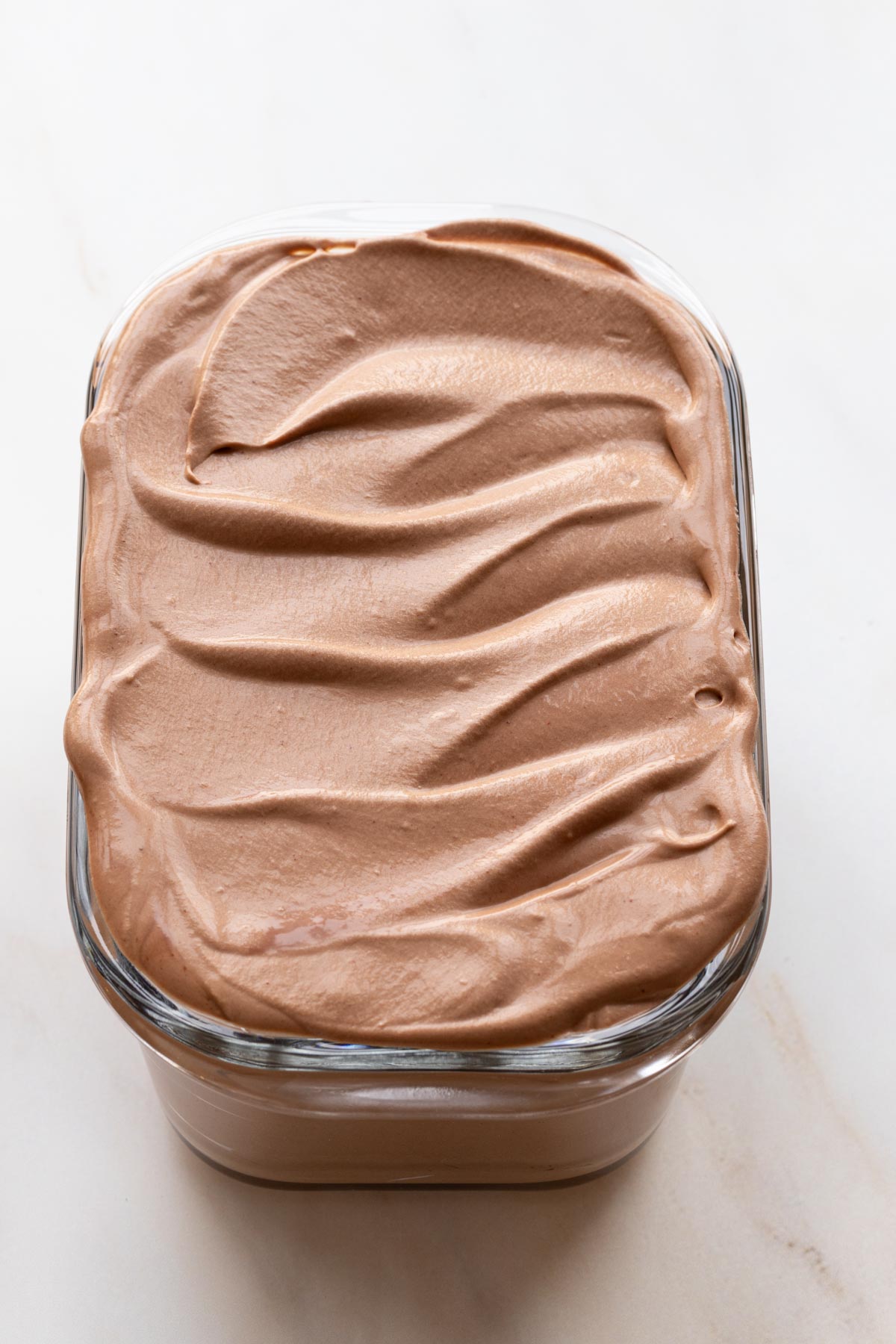 Chocolate no churn ice cream base in a glass container