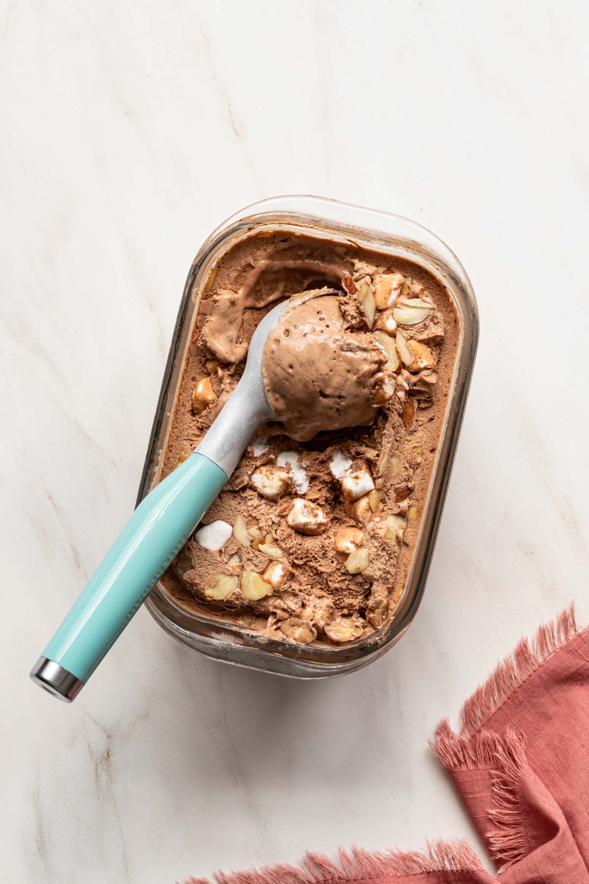 Chocolate no churn rocky road ice cream in a container with an ice cream scoop
