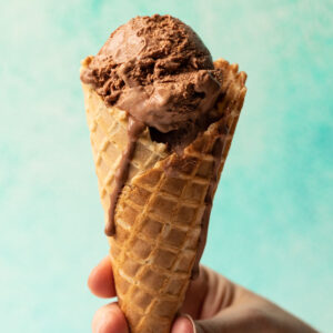 Chocolate no churn ice cream in a waffle cone held in hand