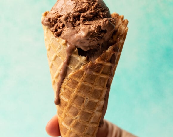 Chocolate no churn ice cream in a waffle cone held in hand