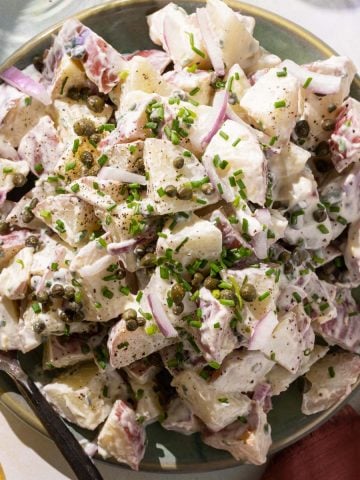 Potato salad with capers on a green plate